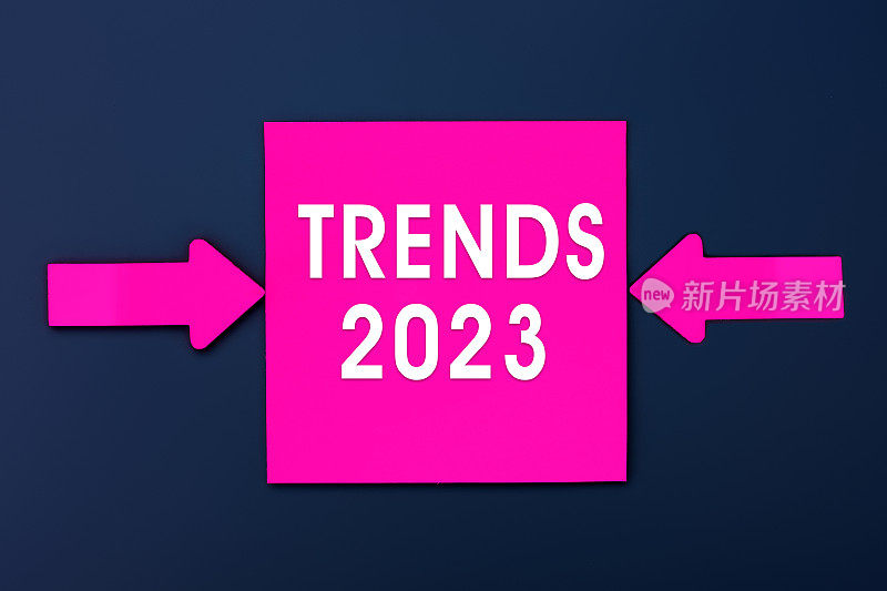趋势2023 -铭文的品红纸备注和两个彩色箭头在深蓝色背景。前视图。企业管理，成功理念的灵感